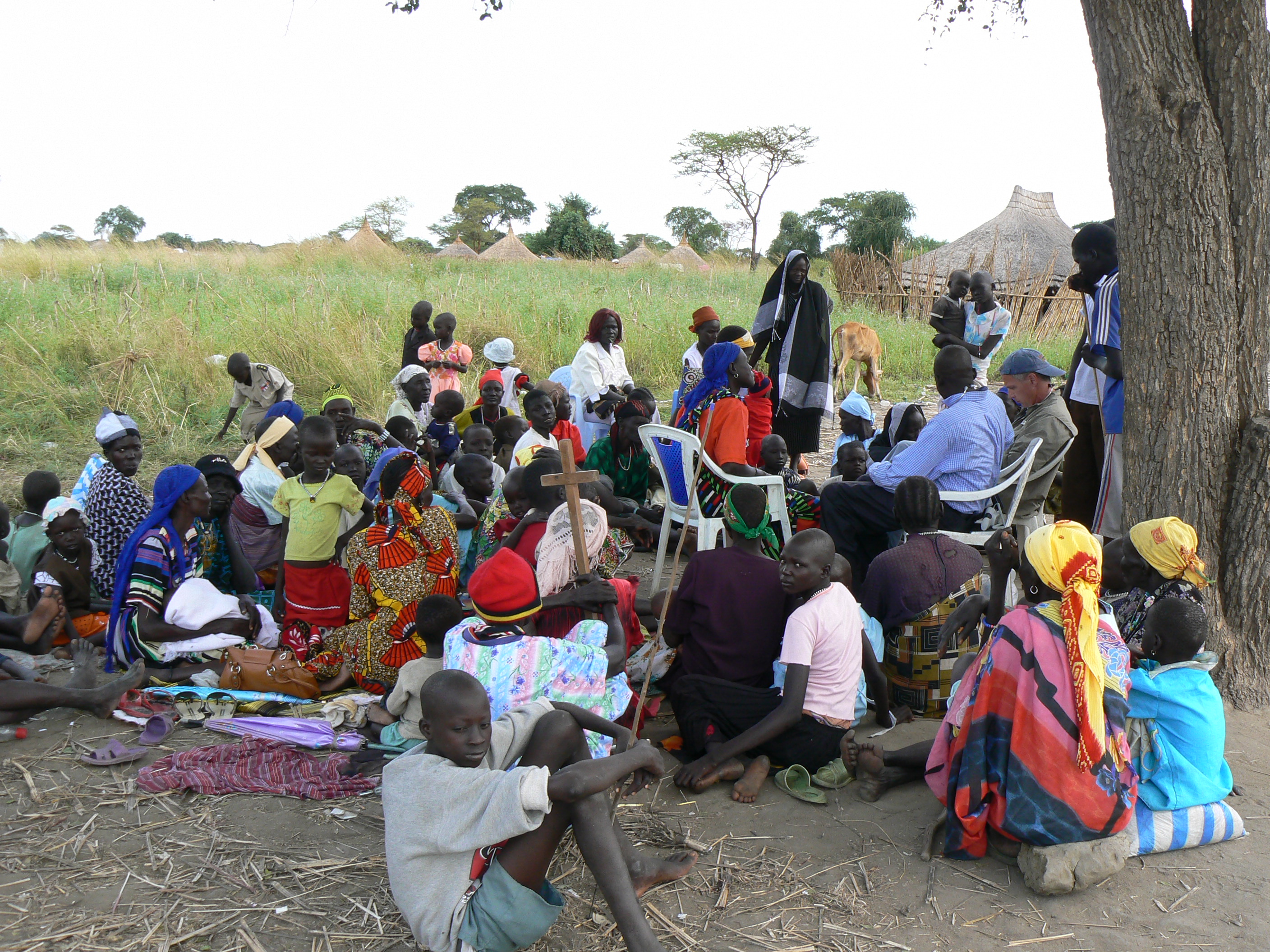 Community gathering under a tree for shared learning and fellowship